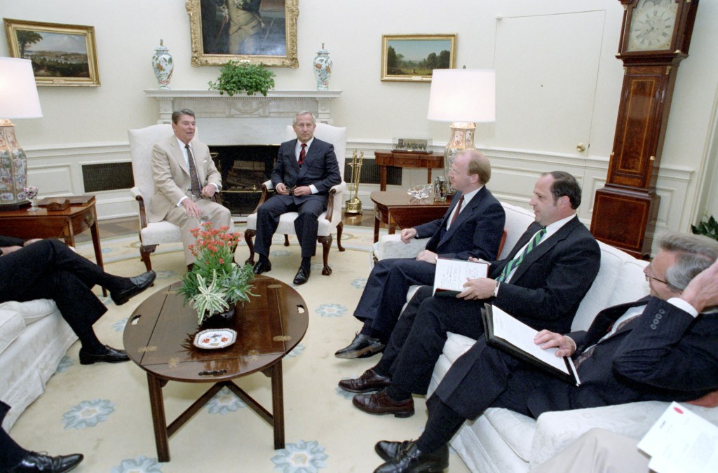 Reagan and Gordievsky center.  Two unidentified men to watch on right.  Carlucci further to the right.  Baker's foot can be seen to the left.  This photo suggests that the two unidentified men are likely British, as it is unlikely any American would sit between the president and his national security adviser.   