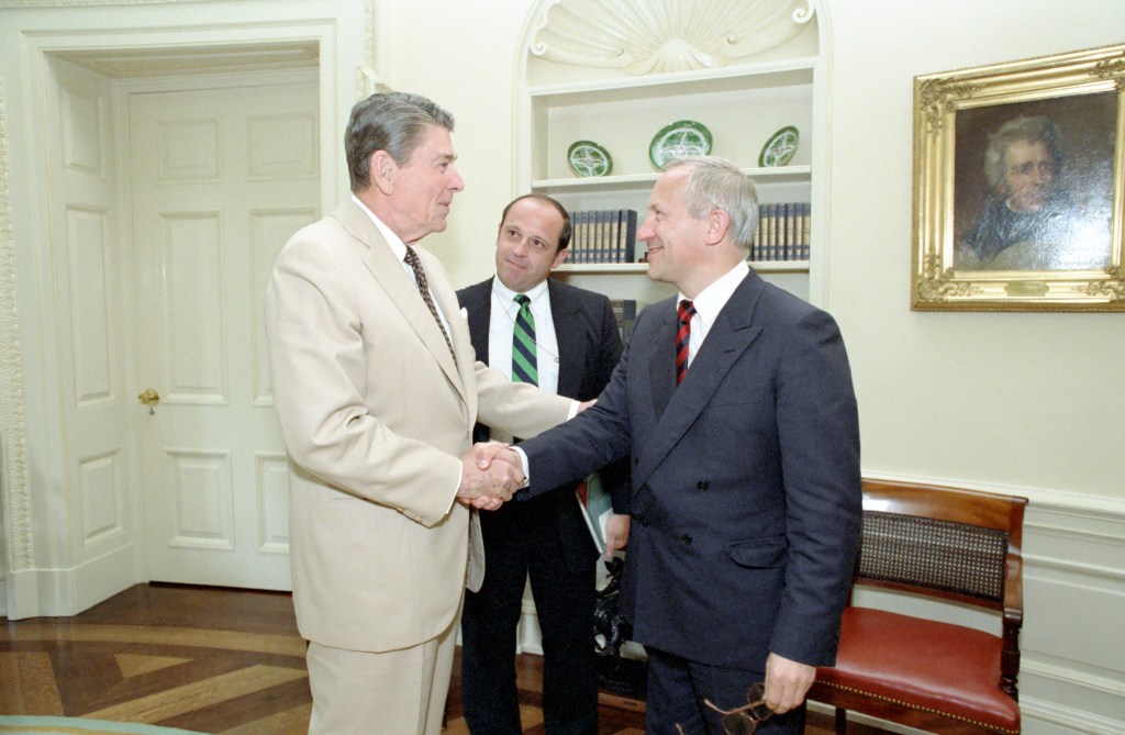 Reagan shaking KGB defector Oleg Gordievsky's hand.  "Unidentified visitor" observes.