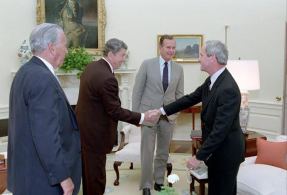 President Reagan, surrounded by White House Chief of Staff Donald Regan and Vice President George H.W. Bush, greets former National Security Advisor Robert McFarlane on his return from Tehran, May 29, 1986. (Photo: Ronald Reagan Library)